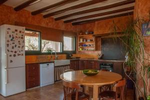 uma cozinha com uma mesa e um frigorífico branco em Cal Cabrer em Masarach
