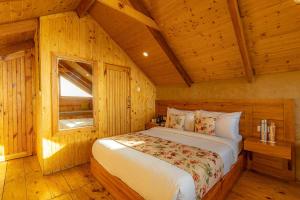 a bedroom with a bed in a wooden cabin at StayVista at Sarion Cottage at Daafi in Theog