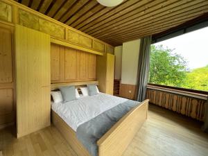 ein Schlafzimmer mit einem Bett und einem großen Fenster in der Unterkunft Aparthotel Hochfeld in Schönau am Königssee