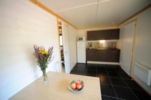 a kitchen and a table with a vase of fruit on it at ULVF Le Domaine de Pelvezy in Saint-Geniès