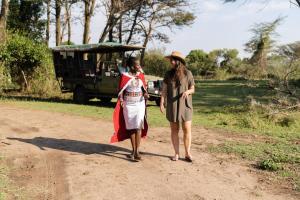 a man and woman walking down a dirt road at Basecamp Adventure in Masai Mara