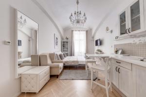 a white kitchen and living room with a couch at Apartments With The Lions in Prague