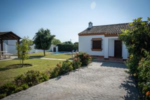 a house with a garden and a driveway at Apartamentos Majadales de Roche in Conil de la Frontera