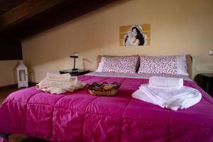a pink bed with towels and a basket on it at Mansarda in centro al quarto piano in Capri Leone
