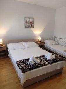 1 Schlafzimmer mit 2 Betten und Handtüchern auf dem Bett in der Unterkunft Apartments"Nika" with private pool in Galovac