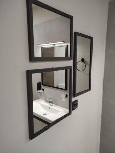 a bathroom with a sink and two mirrors on the wall at Cruzeto in Syvota
