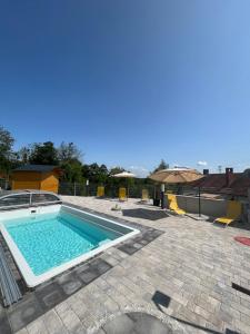 a swimming pool in a yard with chairs and an umbrella at T&T Apartments in Mönchmeierhof