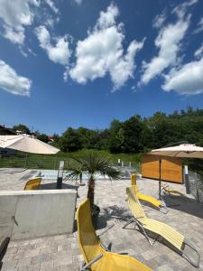 a group of yellow chairs and umbrellas on a patio at T&T Apartments in Mönchmeierhof