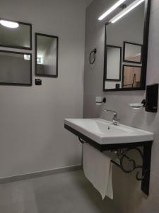 a white bathroom with a sink and a mirror at Cruzeto in Syvota