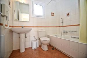 a bathroom with a toilet and a sink and a tub at Timessa Mezonette - Agios Kirikos in Agios Kirykos