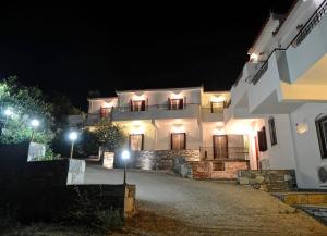 a large white building with lights in the night at Timessa Mezonette - Agios Kirikos in Agios Kirykos