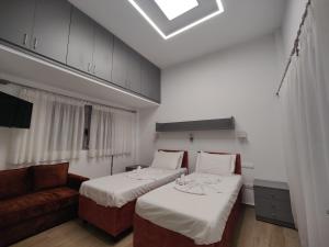 a hotel room with two beds and a couch at Mistral 1 in Artemida