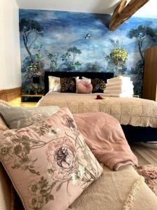 a bedroom with two beds with a painting on the wall at La Colline de Tilleul - De La Colline - Beautiful Cottage Near Aubeterre in Saint-Romain