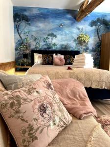 a bedroom with two beds with a painting on the wall at La Colline de Tilleul - De La Colline 4 STAR RATED - Beautiful Cottage Near Aubeterre in Saint-Romain