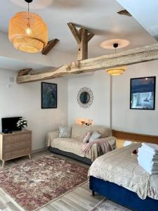 a living room with two beds and a couch at La Colline de Tilleul - De La Colline - Beautiful Cottage Near Aubeterre in Saint-Romain