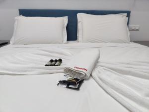 a white bed with two pairs of shoes on it at Mistral 1 in Artemida
