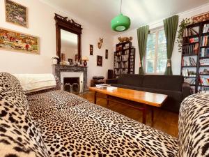 uma sala de estar com um sofá com estampa de leopardo e uma mesa em Maison de maître aux portes du Marais poitevin em La Creche