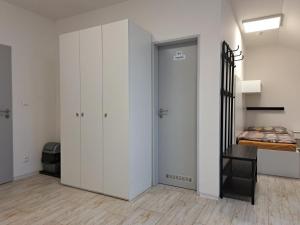 a bedroom with white cabinets and a bed and a closet at Work&Home Stupava in Stupava