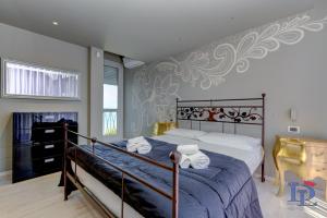 ein Schlafzimmer mit einem Bett mit Handtüchern darauf in der Unterkunft DesenzanoLoft Villa Meraviglia in Desenzano del Garda