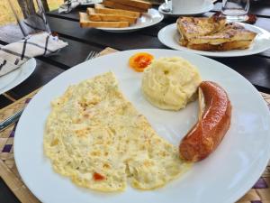 a white plate with omelet and a sausage and bread at Ranakeliya Lodge - Yala in Yala