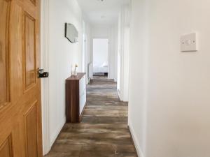 a hallway with white walls and a wooden door at 2BR Hendon Flat - Free Parking & Bus stop outside in Hendon