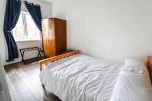 a bedroom with a white bed and a window at 2BR Hendon Flat - Free Parking & Bus stop outside in Hendon +1 photo