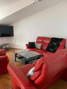 a living room with a red couch and a glass table at Apartments Proxima in Trogir +57 photos