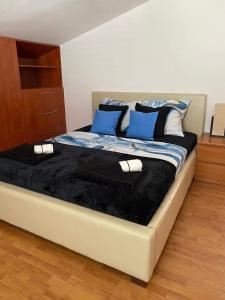 Apartments Proxima في تروغير: سرير عليه وسائد زرقاء في غرفة