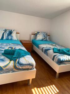 a bedroom with two beds with blue comforter at Apartments Proxima in Trogir