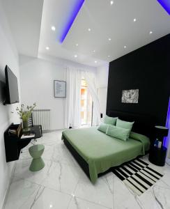 a bedroom with a green bed and a black wall at RaRoom Supernova H in Torre del Greco
