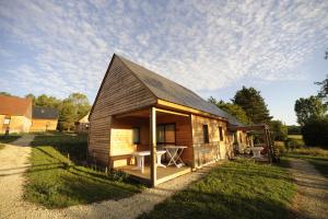 a small wooden cabin with a table in the yard at ULVF Le Domaine de Pelvezy in Saint-Geniès +8 photos