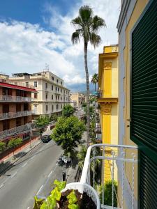 a balcony with a palm tree on a city street at RaRoom Supernova H in Torre del Greco