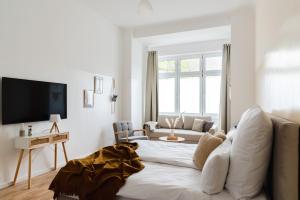 a white living room with a bed and a couch at 165m2 Downtown Family Suite 5BR, 3Bath, kids room, 11min Alexanderplatz in Berlin