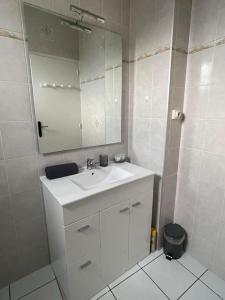a white bathroom with a sink and a mirror at Bizanos - 4 pers, wifi, balcon in Bizanos