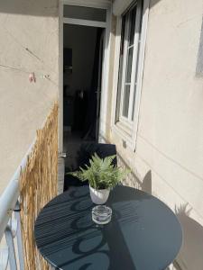 a blue table with a potted plant on a balcony at Bizanos - 4 pers, wifi, balcon in Bizanos