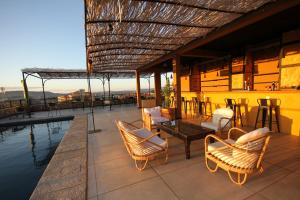 eine Terrasse mit Stühlen, einem Tisch und einem Pool in der Unterkunft Nosy Manga - Hotel Ivato Airport in Antananarivo