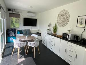 a kitchen and living room with a table and chairs at JANUS COUNTRY SITE Üdülőházak in Szakcs