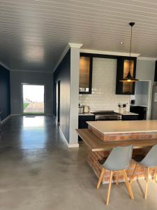 Una cocina y un comedor con mesa y sillas. en The Lake House - Theewaterskloof Golf Estate, en Villiersdorp