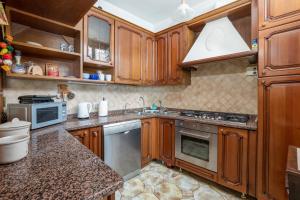 una cocina con armarios de madera y fregadero en A casa di Antonio, en Positano