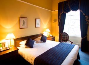 ein Hotelzimmer mit einem Bett und einem Fenster in der Unterkunft Royal Scots Club in Edinburgh