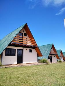 ein Haus mit einem grünen Dach auf einem Feld in der Unterkunft Campo Verde Bungalows in Capitán Miranda