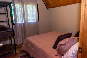 ein kleines Schlafzimmer mit einem Bett und einem Fenster in der Unterkunft Campo Verde Bungalows in Capitán Miranda