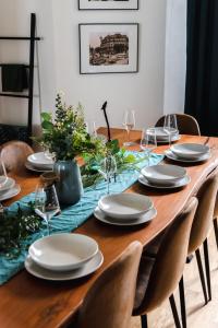 een eettafel met een tafelkleed en borden en stoelen bij 165m2 Downtown Family Suite 5BR, 3Bath, kids room, 11min Alexanderplatz in Berlijn