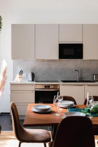een keuken met een houten tafel met stoelen en witte kasten bij 165m2 Downtown Family Suite 5BR, 3Bath, kids room, 11min Alexanderplatz in Berlijn