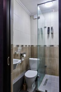 y baño con aseo, lavabo y ducha. en Almaty Central Hostel, en Almaty
