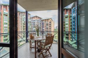 einen Balkon mit einem Tisch und Stühlen sowie einige Gebäude in der Unterkunft Bright Apartment near Parco Dora by Wonderful Italy in Turin