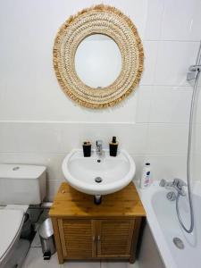 baño con lavabo y espejo en la pared en L’élégance de Versailles depuis le Chesnay, en Le Chesnay