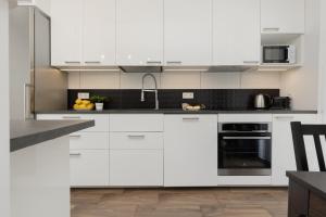 a white kitchen with white cabinets and appliances at Apartment Warsaw Goclaw & 2 bedrooms & Parking & Balcony by Renters in Warsaw