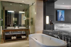 a bathroom with a bath tub and a bed at The Westin Doha Hotel & Spa in Doha