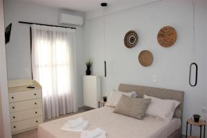 a bedroom with a bed and a dresser and a window at Théa Apartment in Rethymno Town